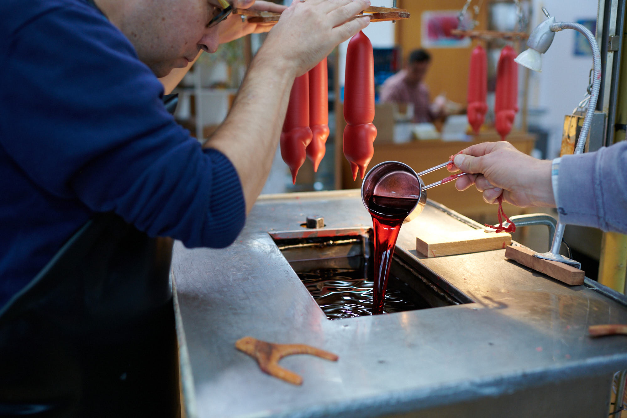 Herstellung von traditionellen Kerzen in einer Kerzenwerkstatt Handwerker bei der Produktion von roten Tauchkerzen in einer Werkstatt