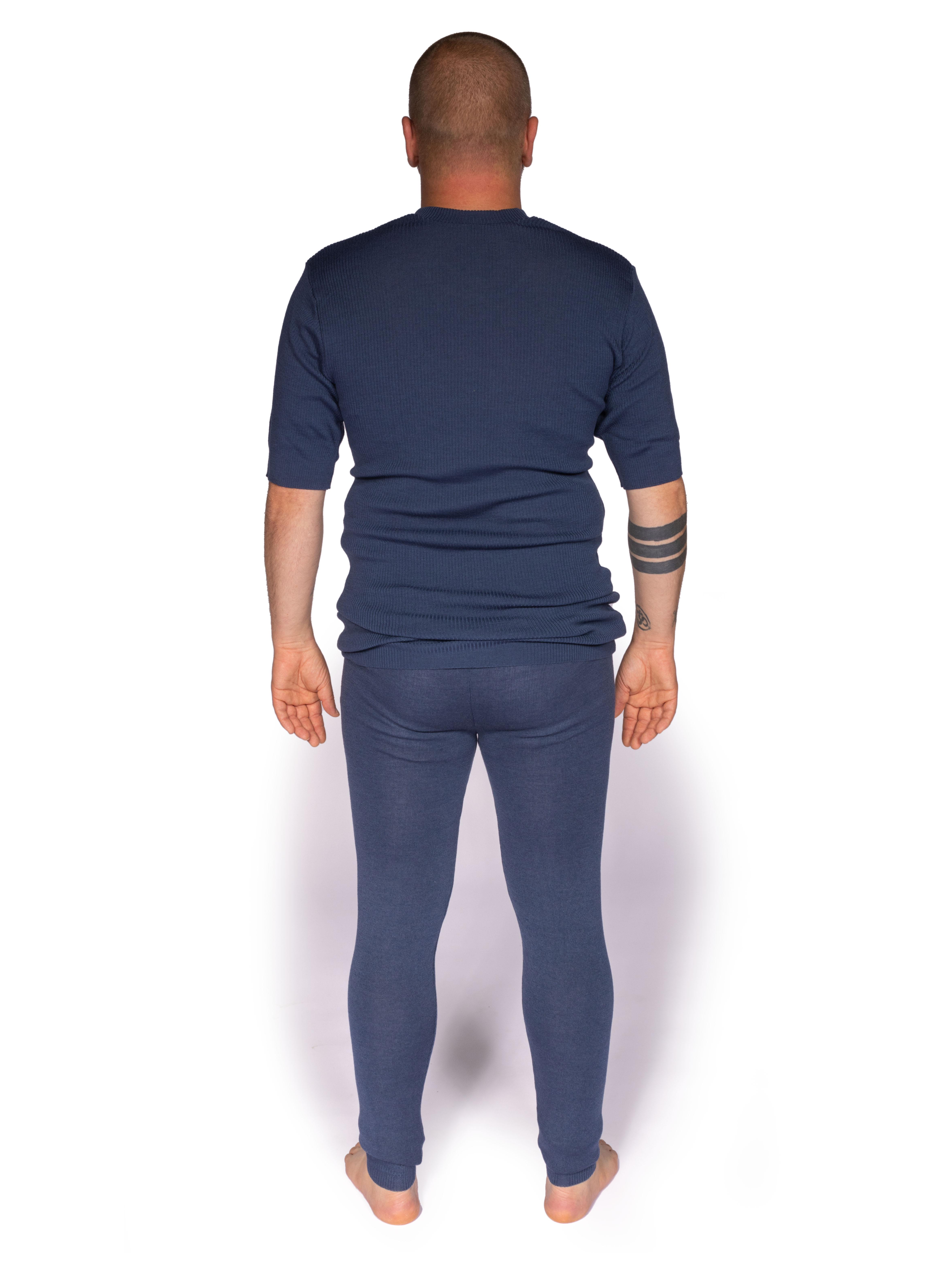 Hinteransicht eines Mannes in blauer Thermounterwäsche Ein Mann steht in blauer Thermounterwäsche mit kurzer Oberteilärmel und langer Hose, fotografiert von hinten