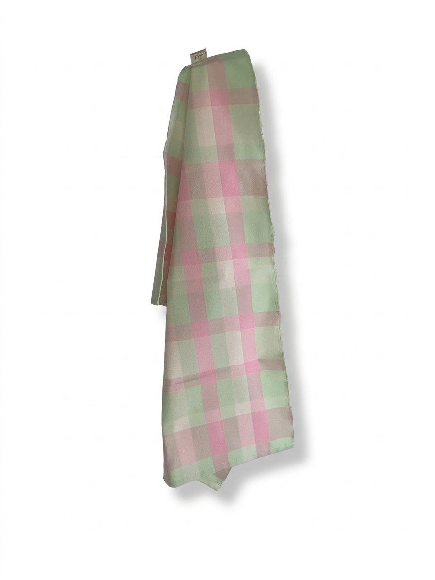 Aufgehängtes Geschirrtuch mit pastellgrün-rosa Karomuster auf weißem Hintergrund
