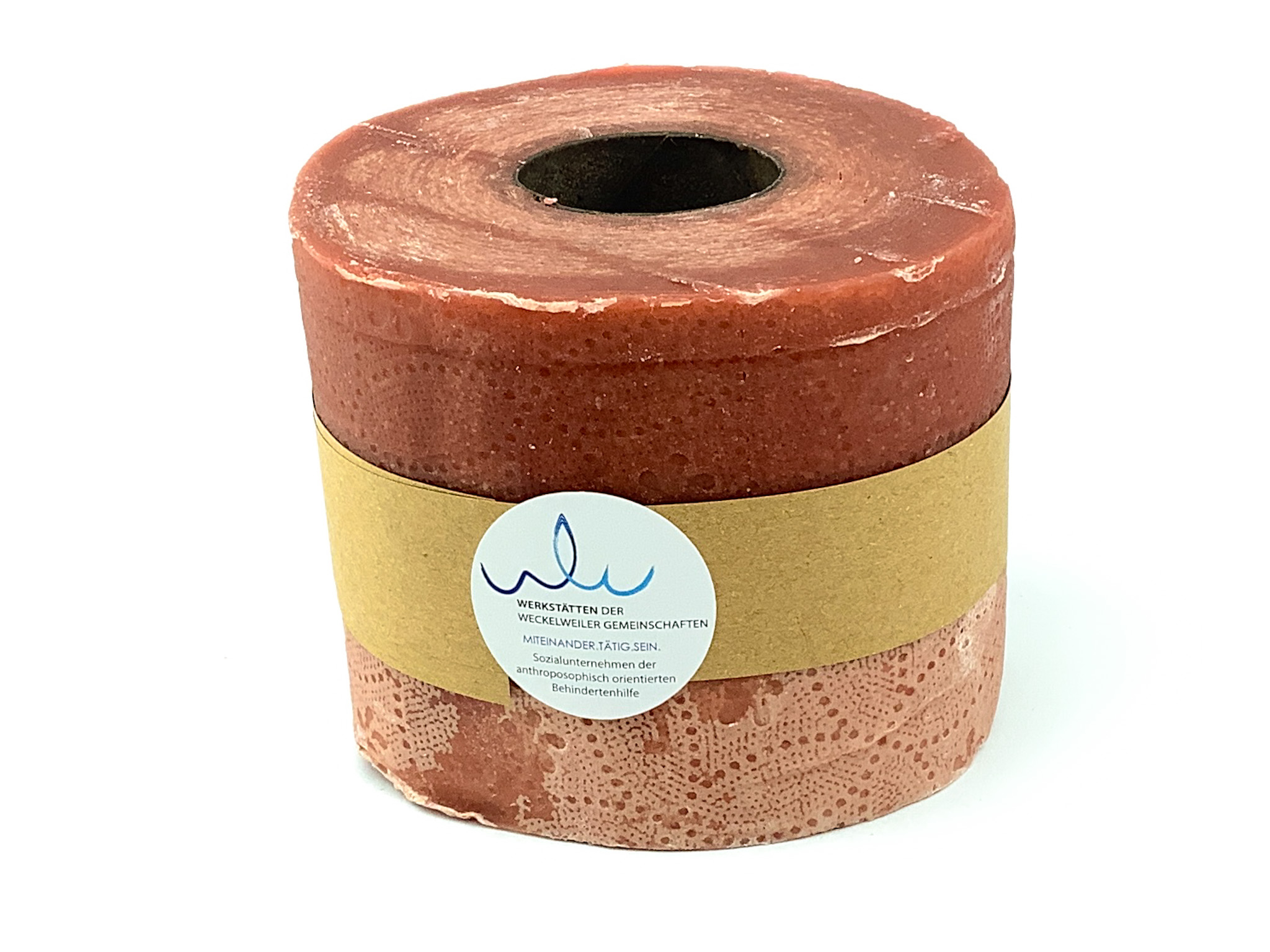 Handgefertigte rote Kerze in Rollenform Handgefertigte rote Kerze in Rollenform mit Etikett der Werkstätten der Weckelweiler Gemeinschaften