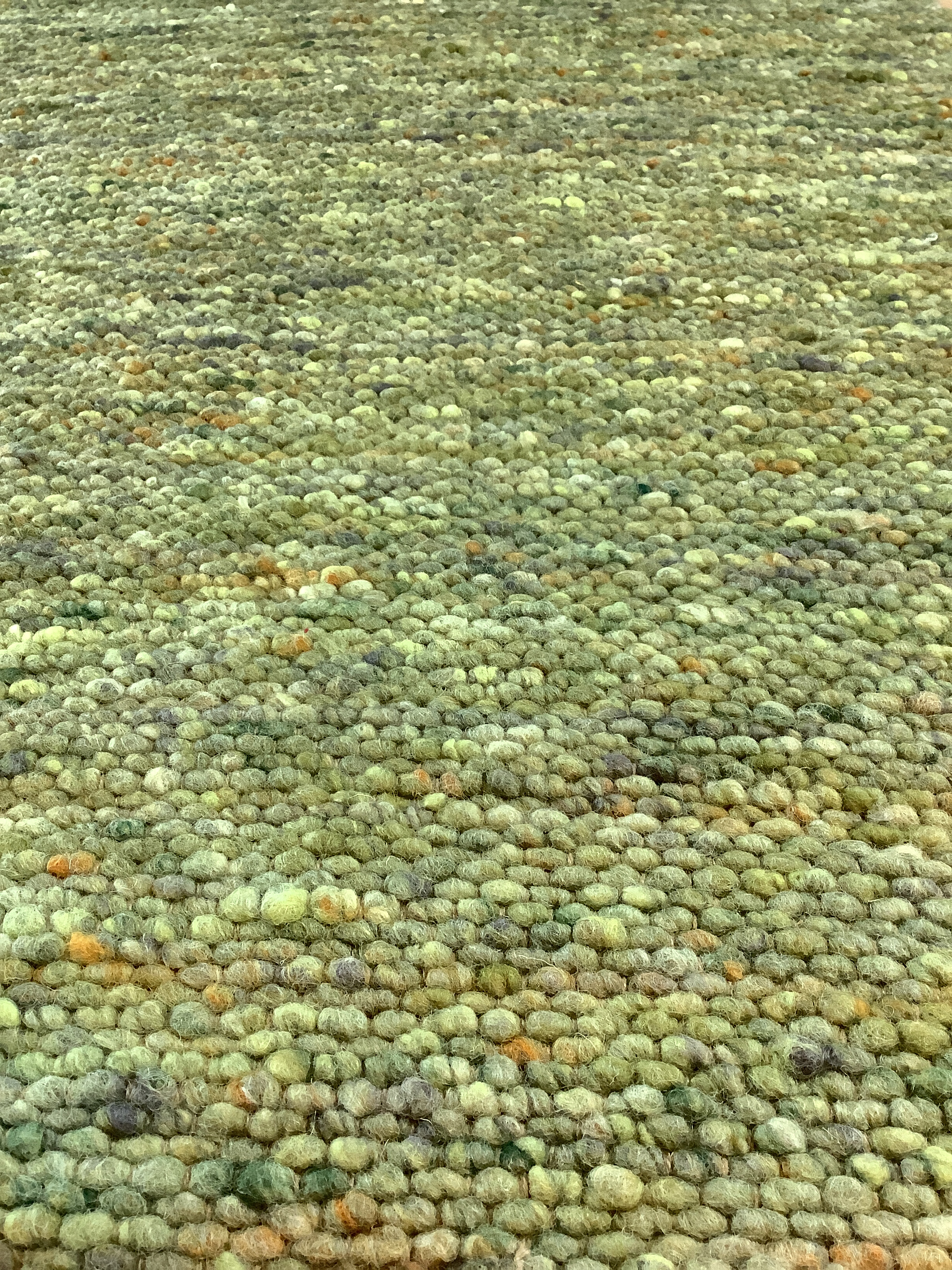 Grüner Teppich aus grob gestrickter Wolle Nahaufnahme eines grünen Teppichs mit grober Strickstruktur aus Wolle