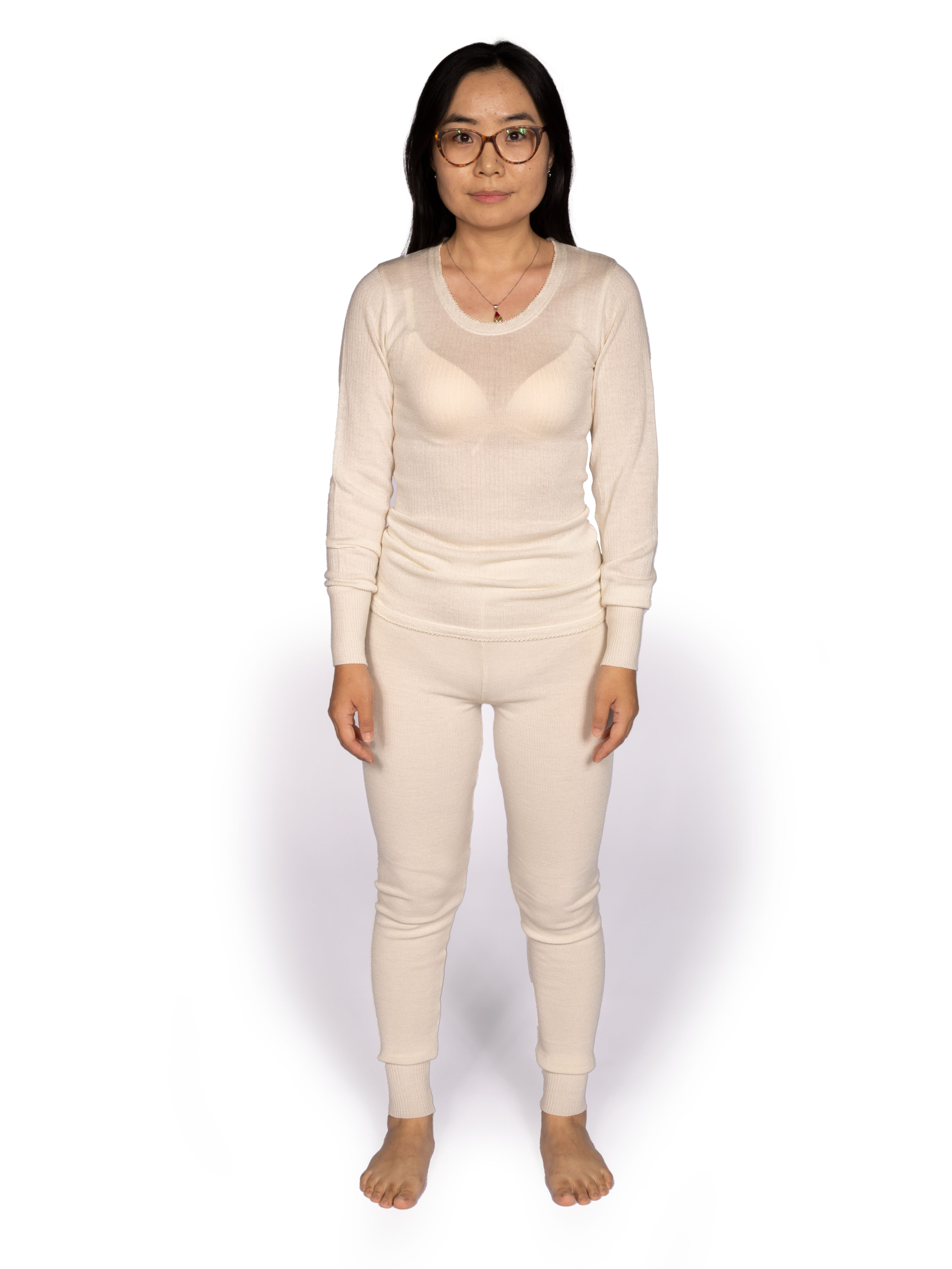 Bequemes Thermo-Unterwäsche-Set für Damen Frau trägt ein beiges Thermo-Unterwäsche-Set bestehend aus Oberteil und Hose