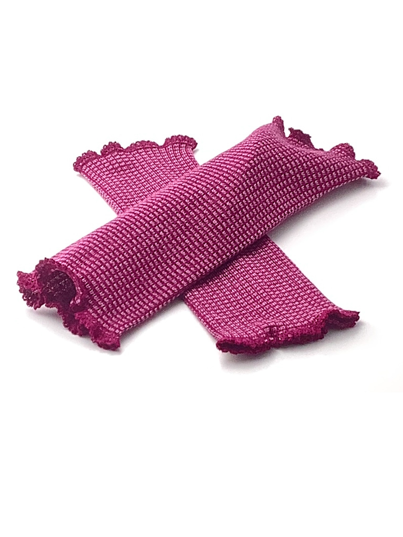 Magenta Strickärmel mit Rüschenrand Ein Paar magentafarbene Strickärmel mit dekorativem Rüschenrand auf weißem Hintergrund