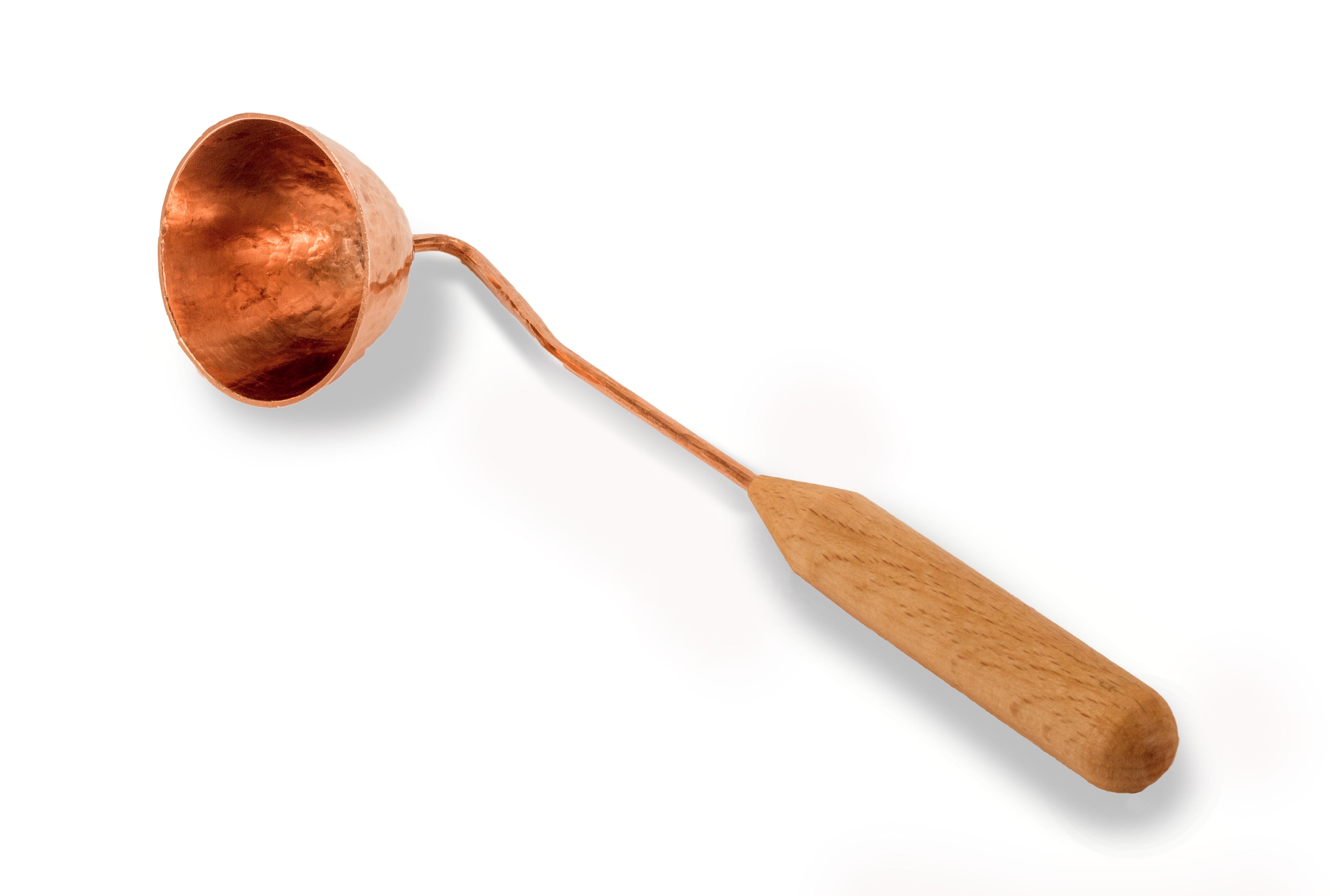 Traditionelle Kupferkelle mit Holzgriff Handgeschmiedete Kupferkelle mit ergonomischem Holzgriff auf weißem Hintergrund
