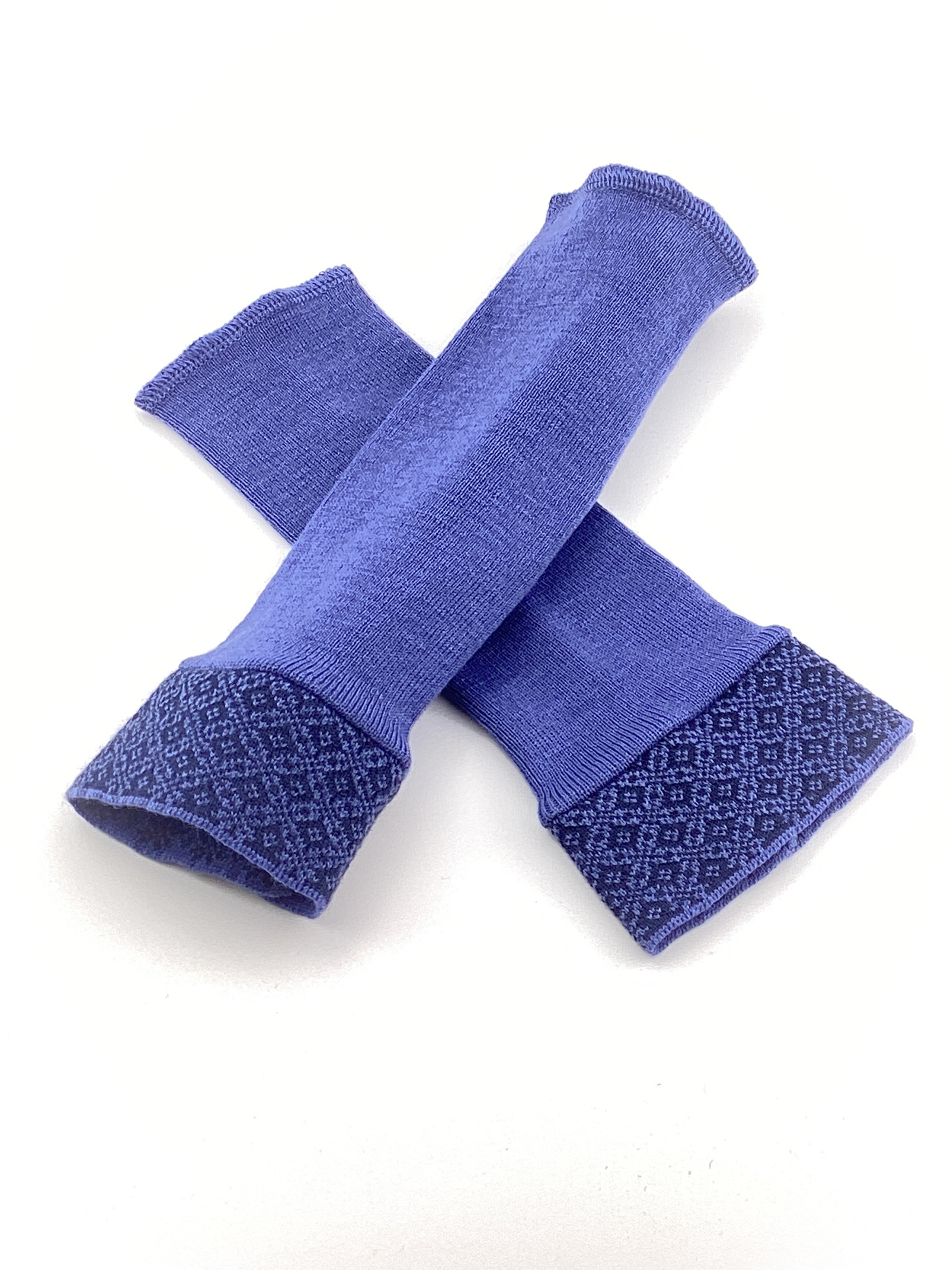 Lila Stulpen mit Rautenmuster aus weichem Strickmaterial Zwei lila Stulpen mit feinem Rautenmuster auf hellem Hintergrund