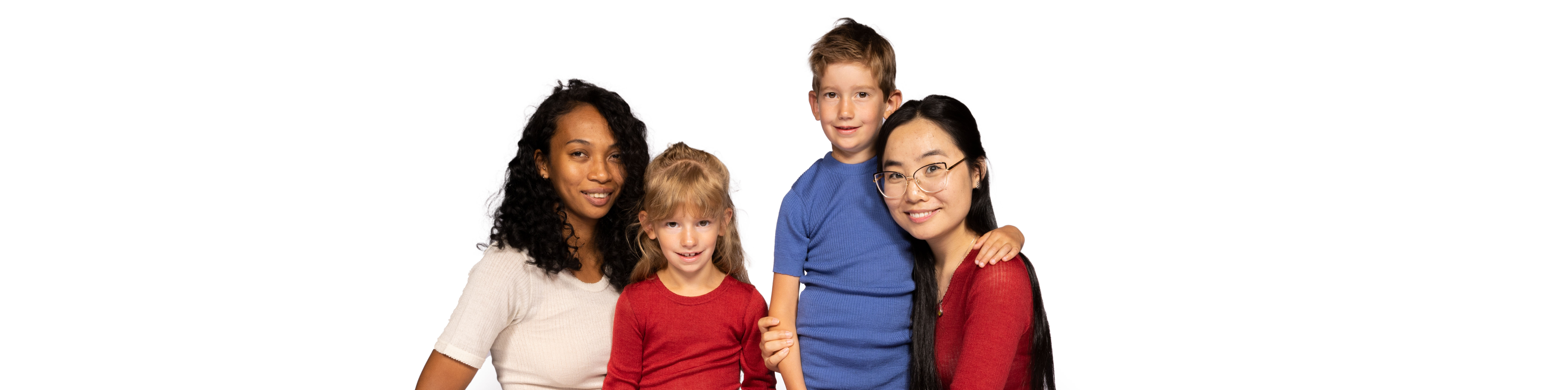 Vier Personen, zwei Erwachsene und zwei Kinder, lächelnd in die Kamera schauend