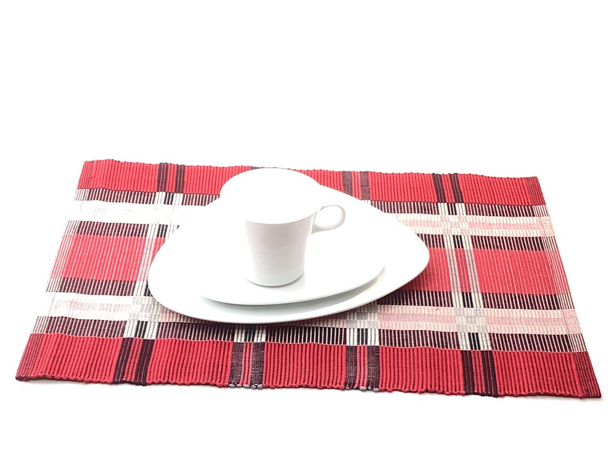 Rotes Tischset mit Tasse und Teller Weißes Geschirr auf rotem kariertem Tischset