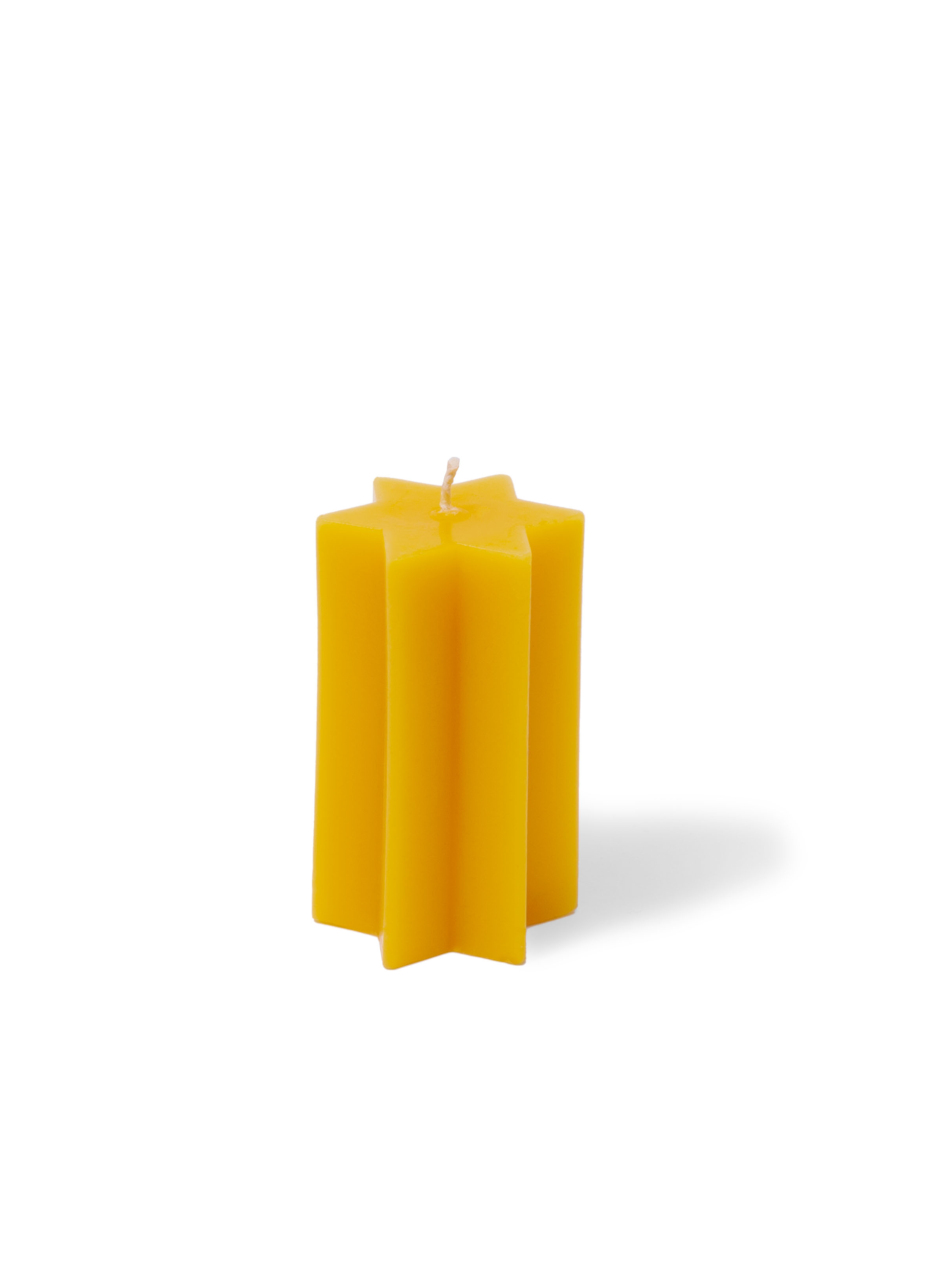 Gelbe sternförmige Kerze Gelbe sternförmige Kerze auf weißem Hintergrund