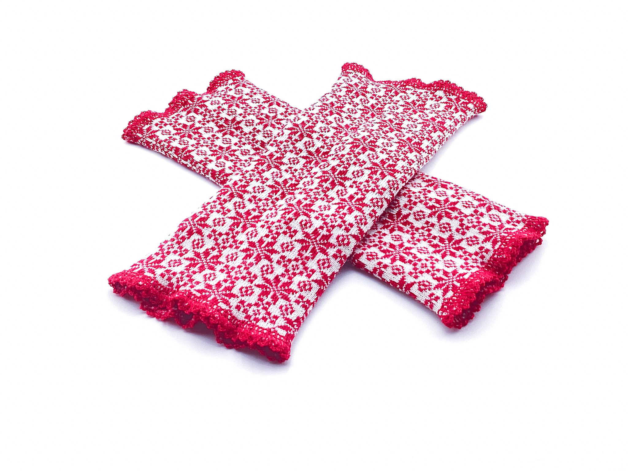 Handgestrickte Armstulpen mit norwegischem Muster in Rot und Weiß Zwei handgestrickte Armstulpen mit rotem und weißem norwegischem Muster, auf weißem Hintergrund