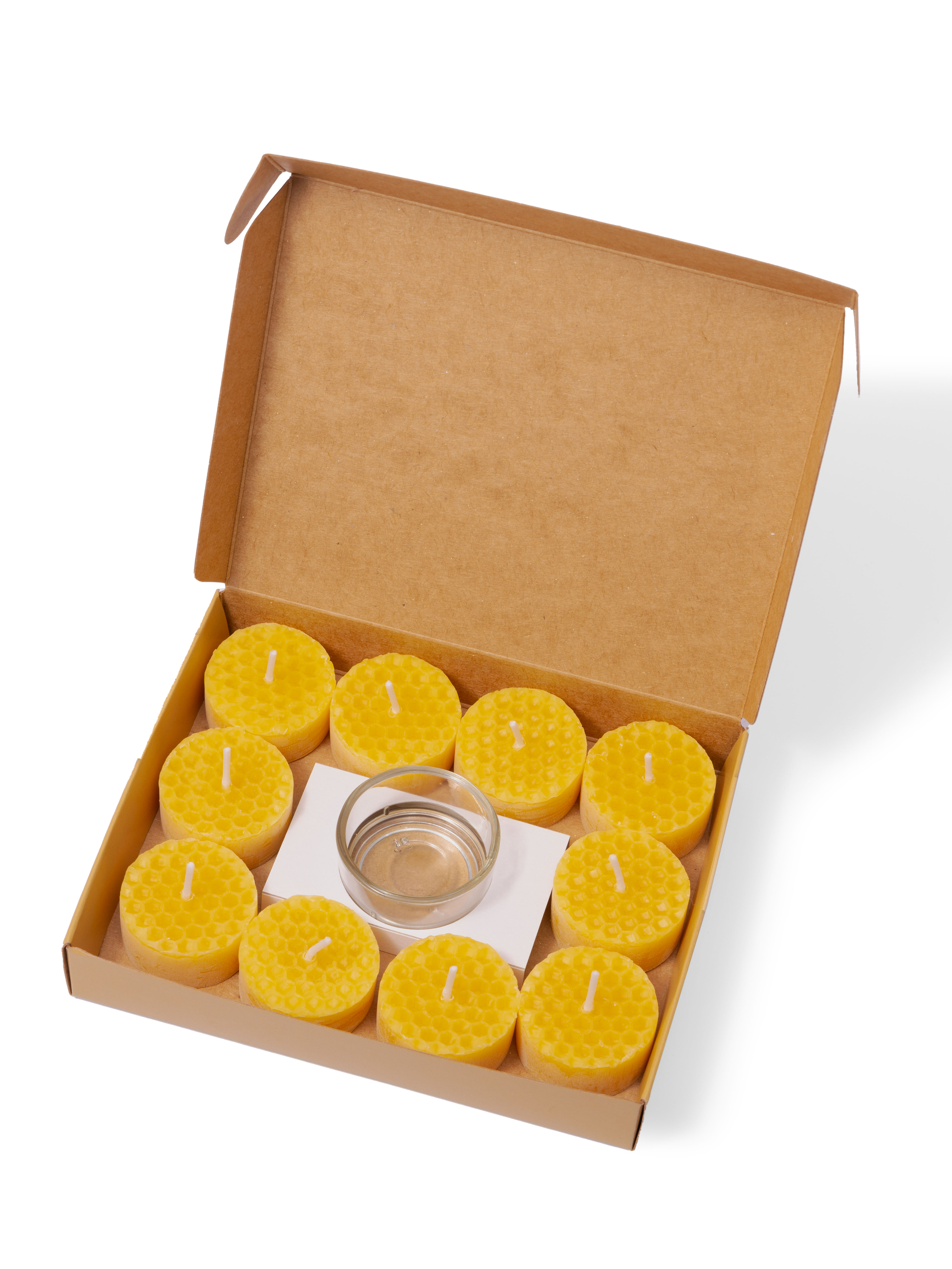 Set aus 10 gelben Bienenwachsteelichtern in Pappkarton Geöffnete Schachtel mit 10 gelben Bienenwachsteelichtern, ein Glas und Pappkarton