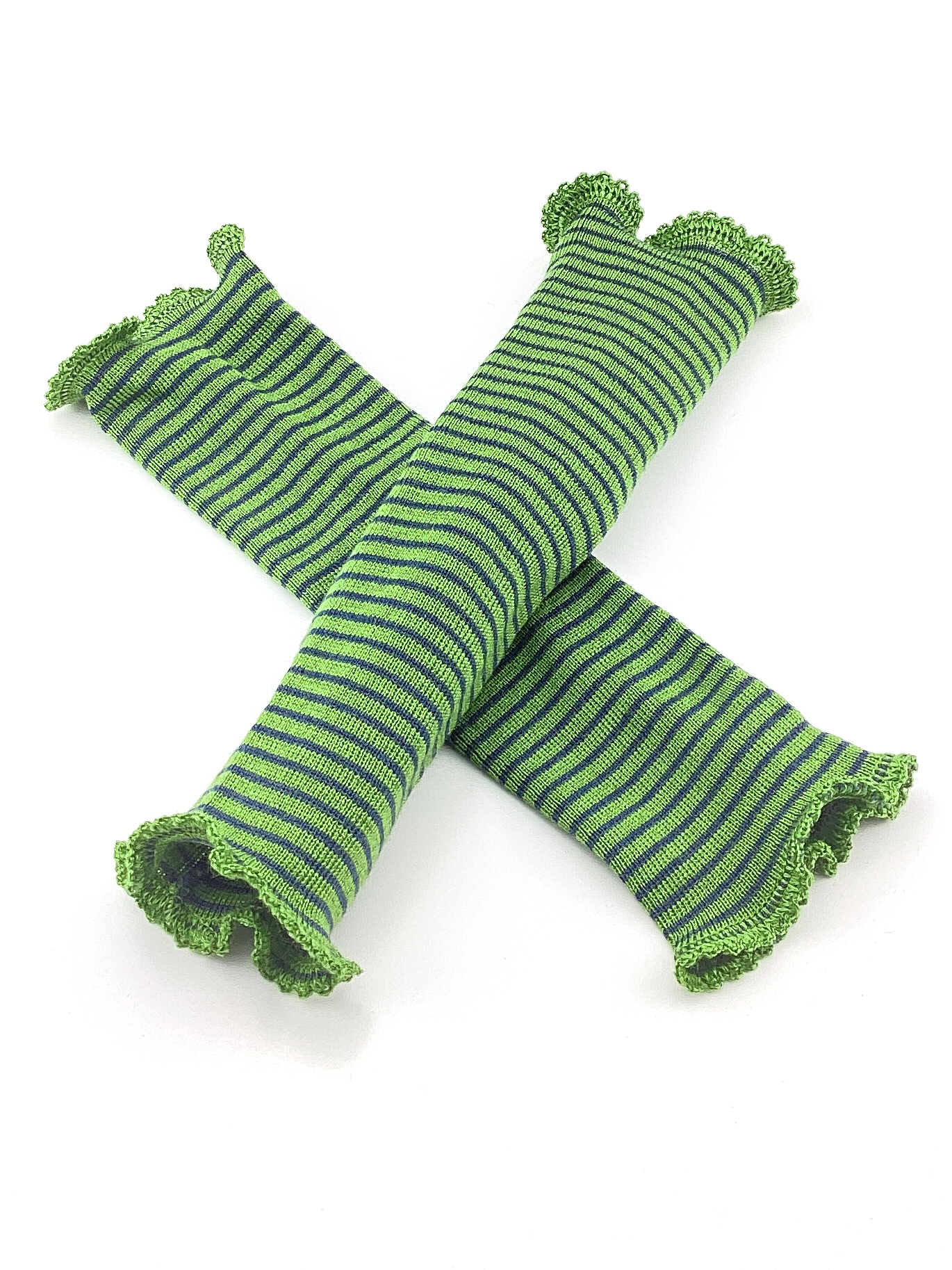 Gestrickte Armstulpen in Grün mit Streifenmuster Zwei grün gestreifte Armstulpen aus gestricktem Material, dekorativ übereinandergelegt