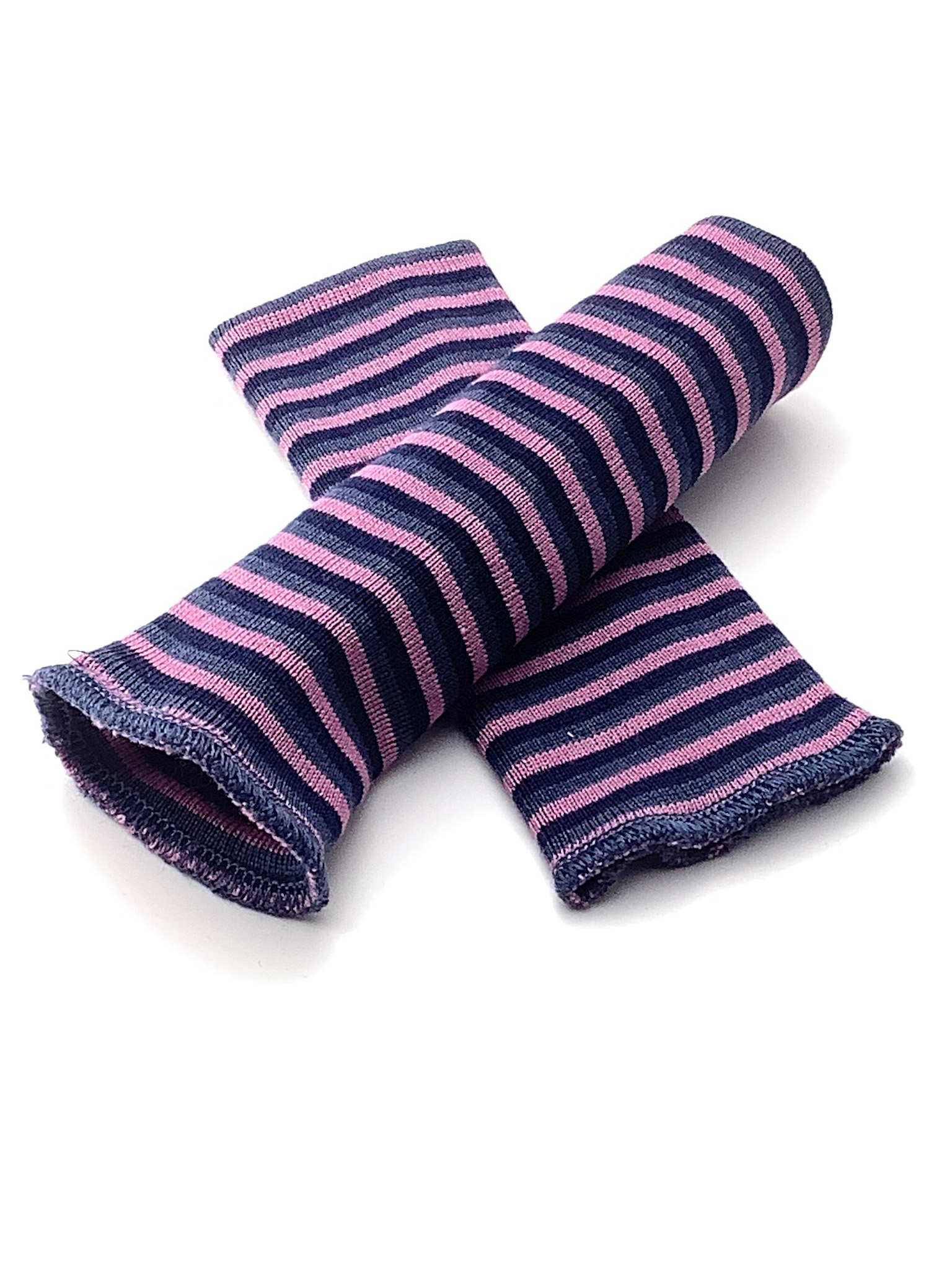 Gestreifte Armstulpen in Blau und Rosa aus Baumwolle Zwei gestreifte Armstulpen in Blau und Rosa aus Baumwolle, gekreuzt liegend auf weißem Hintergrund