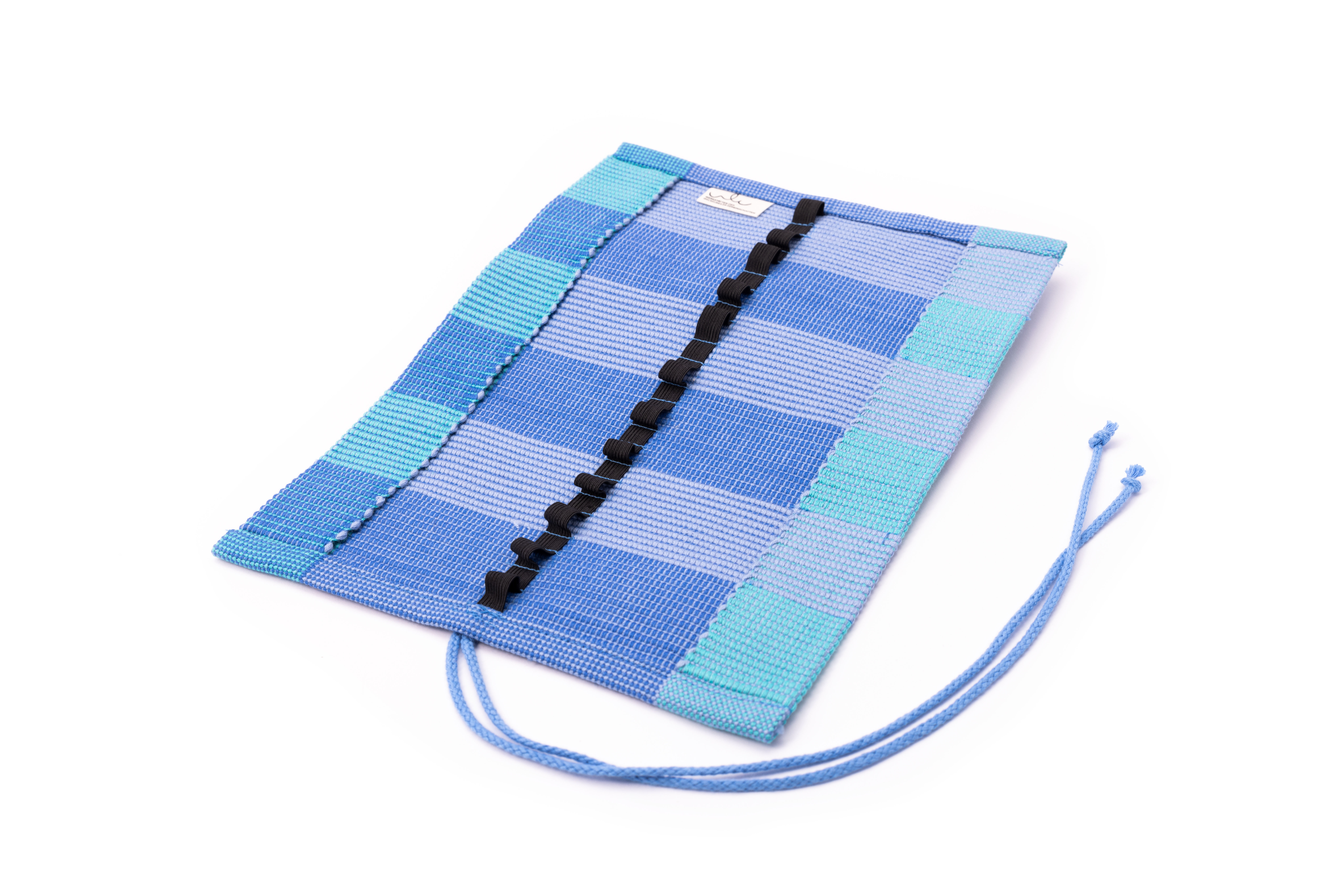 Blau gestreifte Textiltasche mit Bändern Eine blau gestreifte Textiltasche mit dekorativen Bändern und Kordeln