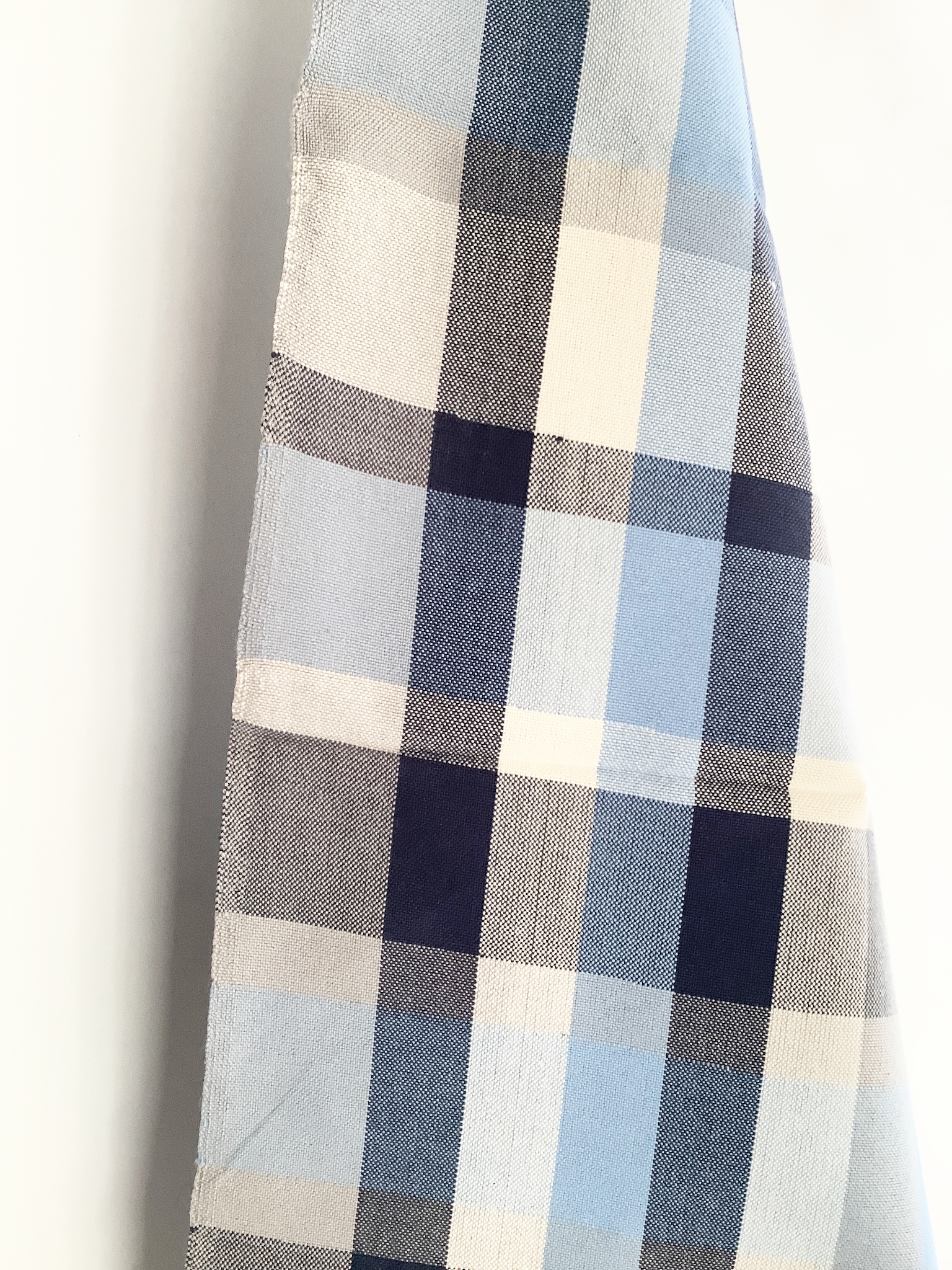 Nahaufnahme eines Geschirrtuchs aus Baumwolle mit blauem Karomuster in verschiedenen Blautönen und Beige