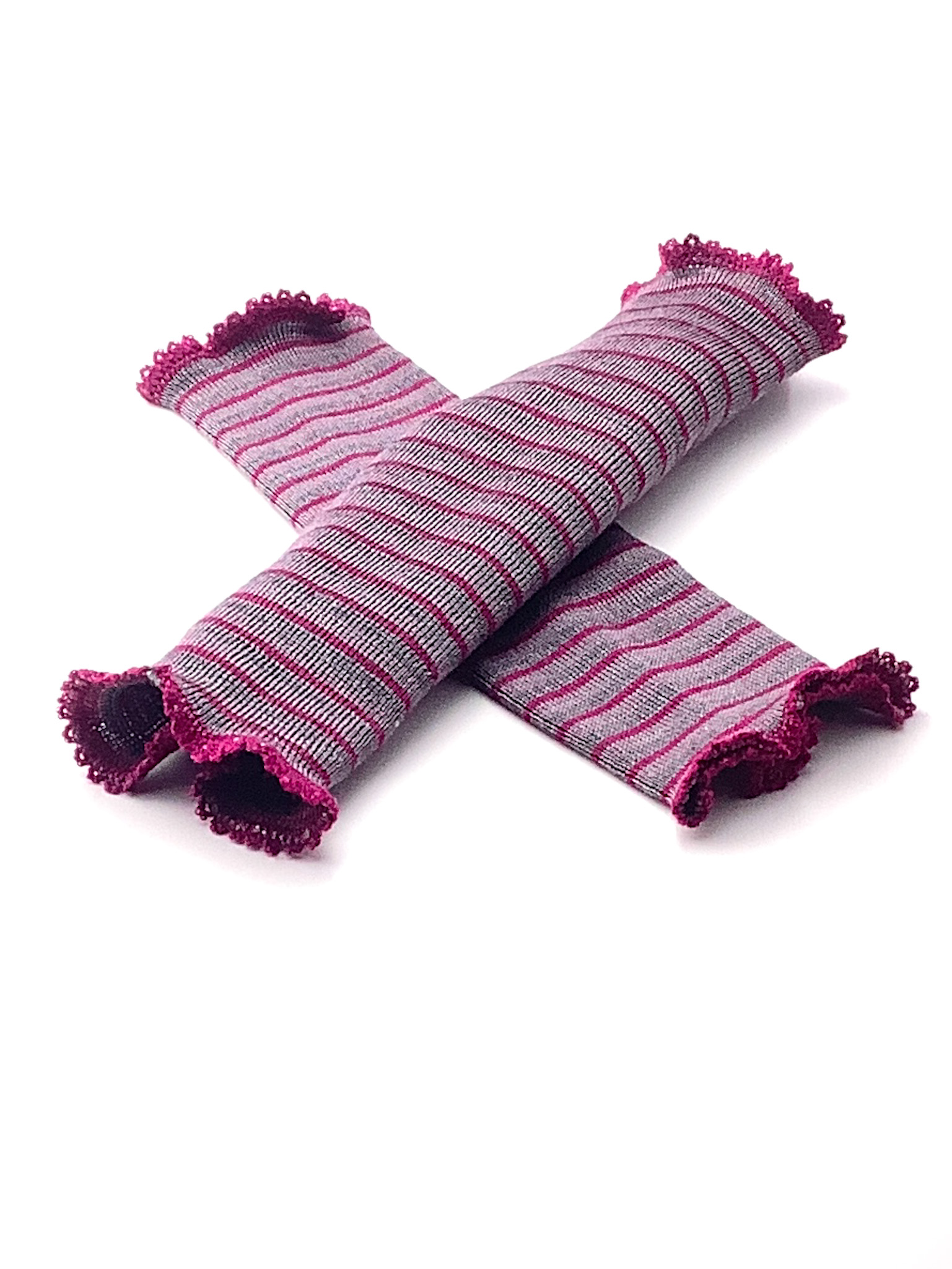 Gestreifte Armstulpen in Pink und Grau Zwei gestreifte Armstulpen in Pink und Grau liegen gekreuzt auf weißem Hintergrund