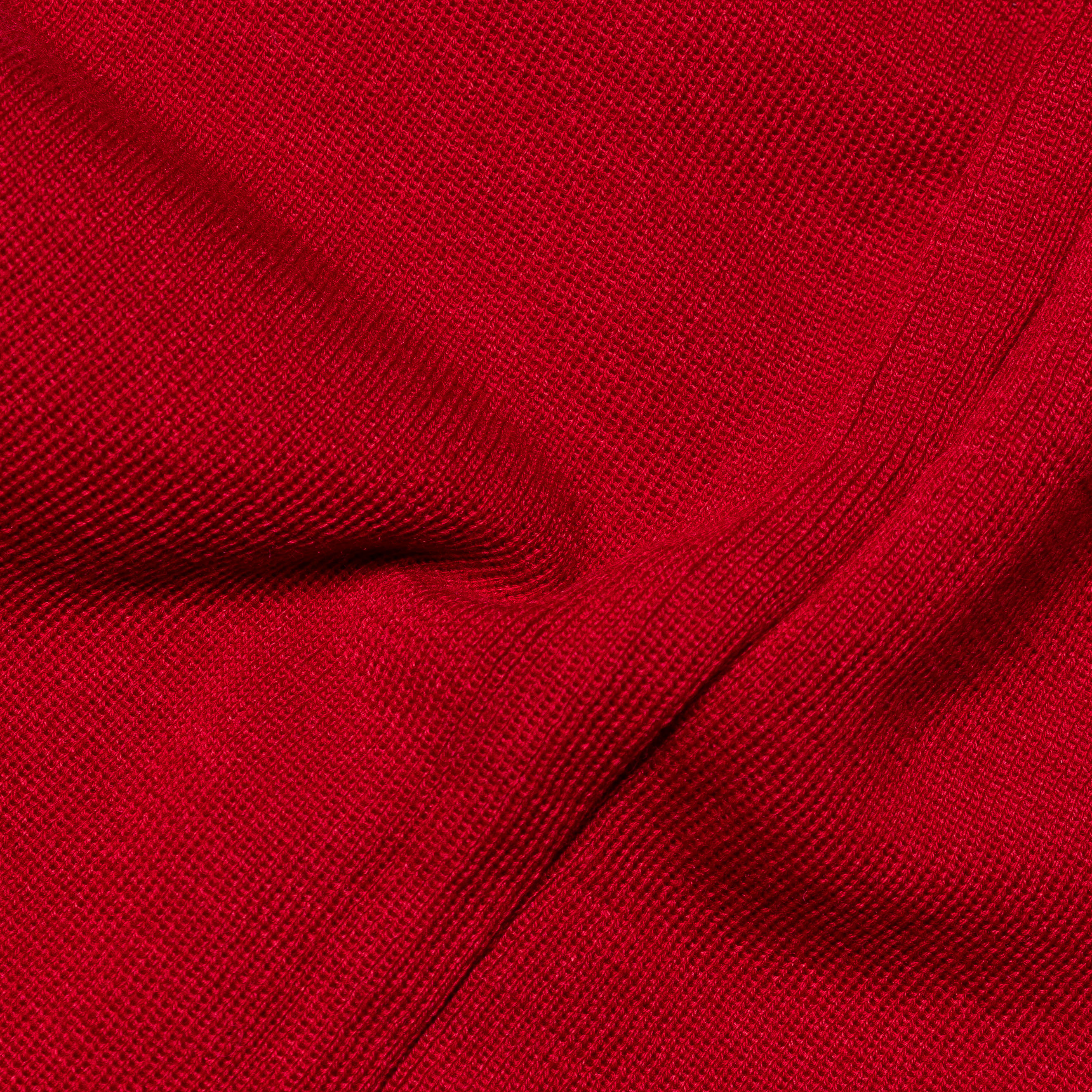 Nahaufnahme eines roten, strukturierten Stoffes, der eine feine Webung zeigt